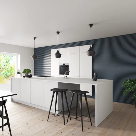 Bright kitchen with white cabinets, island, wooden floor, and three black pendant lights.