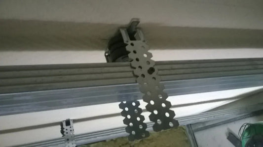 Ceiling insulation installation with metal support strips.