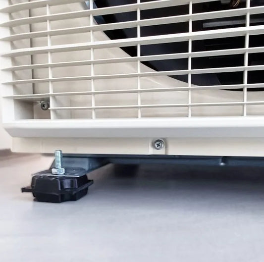 Close-up of an air conditioner's base, showing a black rubber foot with a bolt and washer.