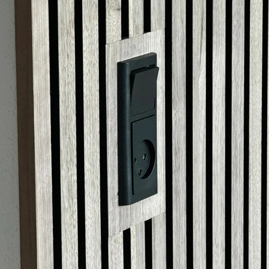 Close-up of a black electrical switch and outlet mounted on a wooden slat wall.