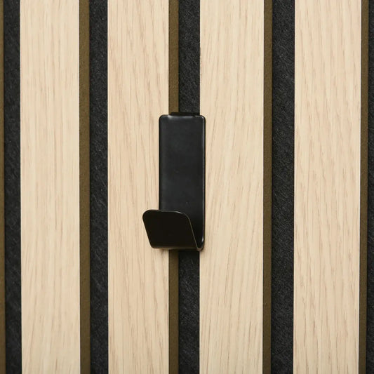 Close-up of a black hook mounted on a light wood and dark fabric paneled wall.
