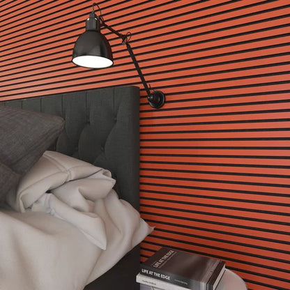 Bedroom with black and orange striped wall, gray headboard, white bedding, and black swing arm lamp.