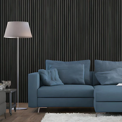 Living room with blue couch, floor lamp, and black paneled wall.

