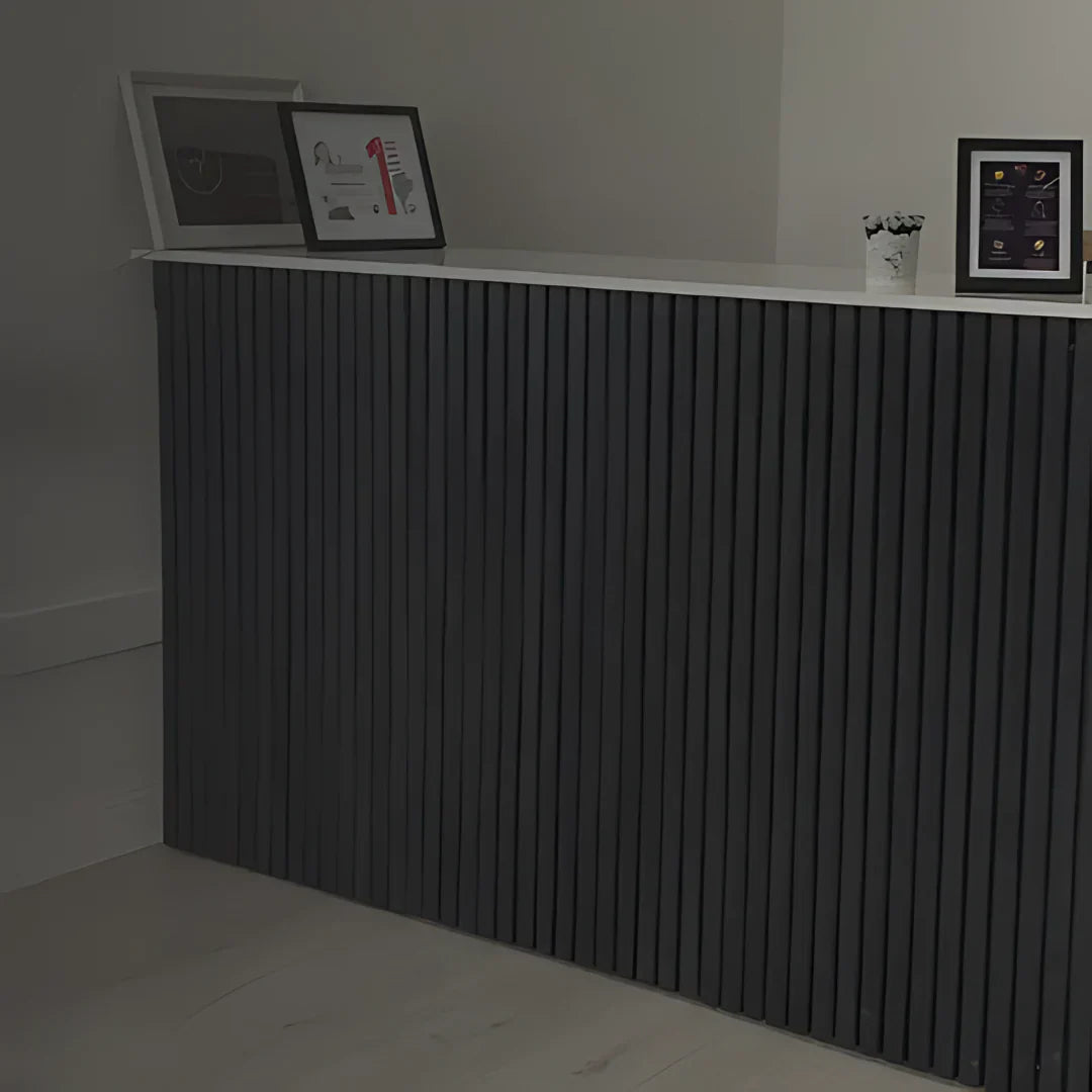 A gray counter with a white top and three framed pictures.
