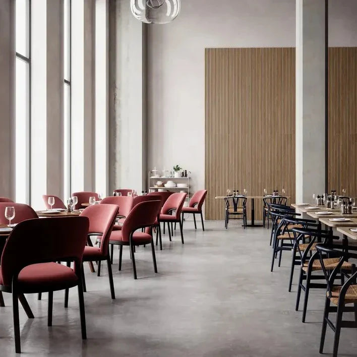 Restaurant interior with pink chairs and blue chairs.