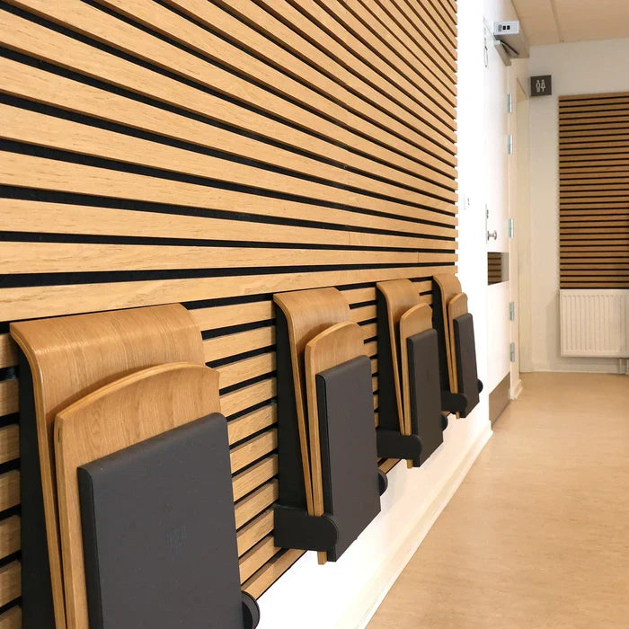 A hallway with wood-paneled walls and folded chairs.
