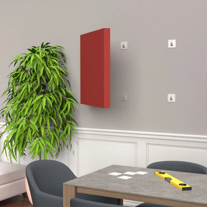 Interior room with red wall art, plant, gray chairs, and a table with a level and white squares on top.