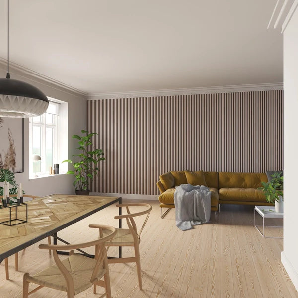 A bright, modern living space with a wooden dining table and chairs, a mustard-colored sofa, and a vertically paneled wall.