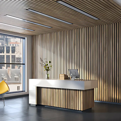 Office reception area with wood-paneled walls and ceiling, white counter, vase of greenery, and office supplies.