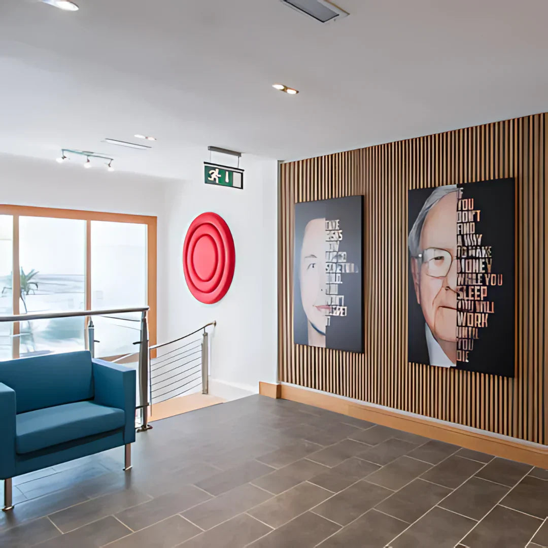 A room features a blue armchair, a red circular wall decoration, and wall art with portraits and text.