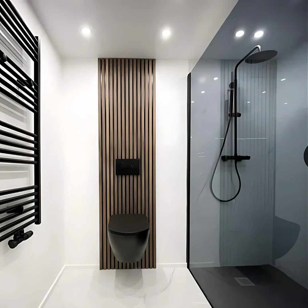 Modern minimalist bathroom with black fixtures, wood accent wall, and glass shower.
