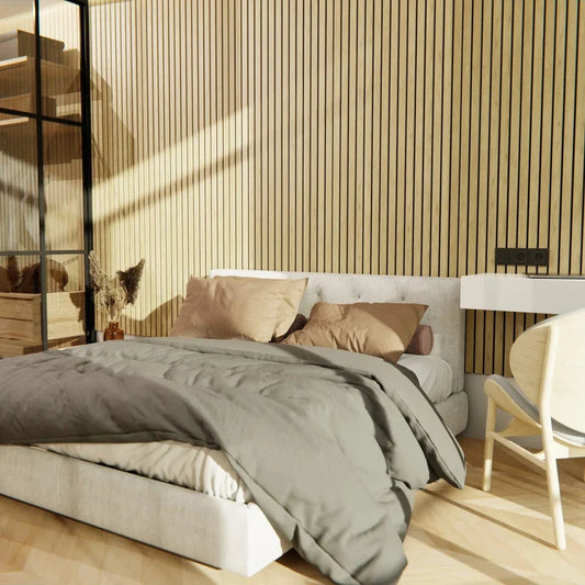 Bedroom with gray bedding, beige pillows, and light wood furniture against a wood slat wall.