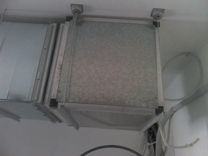 Ceiling-mounted metal ductwork with support rods and various utility pipes.
