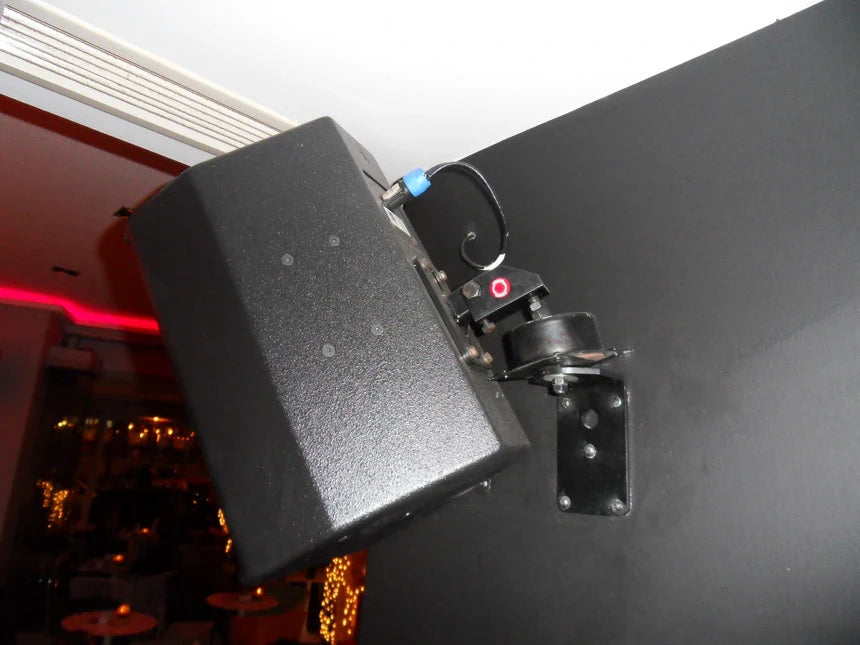 Wall-mounted black loudspeaker.