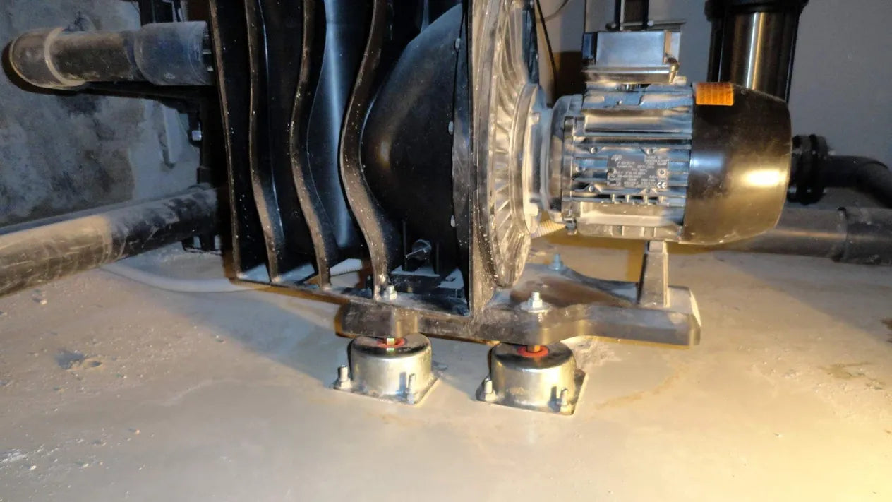 Black industrial pump and motor mounted on vibration isolators.