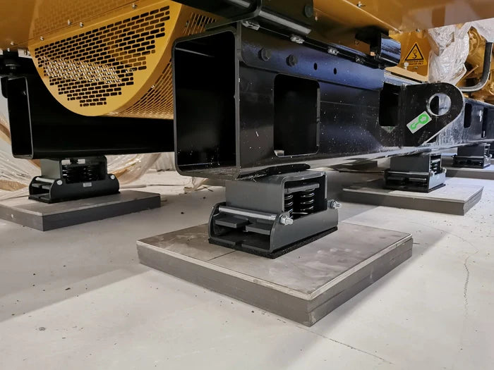 Industrial machinery supported by anti-vibration mounts on concrete pads.