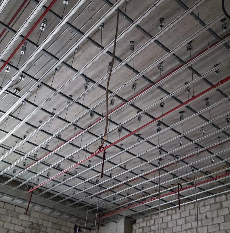 Exposed ceiling frame with red pipes.
