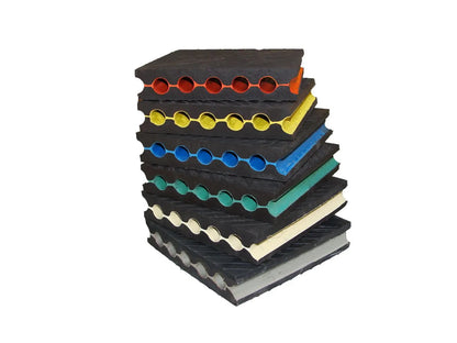 Stacked, multi-colored rubber mats with circular cutouts.
