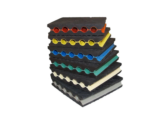 Stacked, multi-colored rubber mats with circular cutouts.
