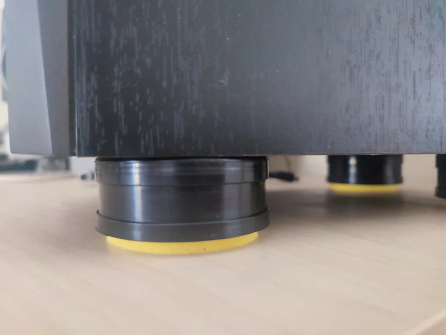 A black piece of furniture sitting on yellow foam pads.