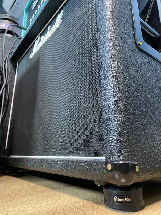 Close-up of a black Marshall amplifier cabinet with "Vibro FÖN" labeled isolation feet.