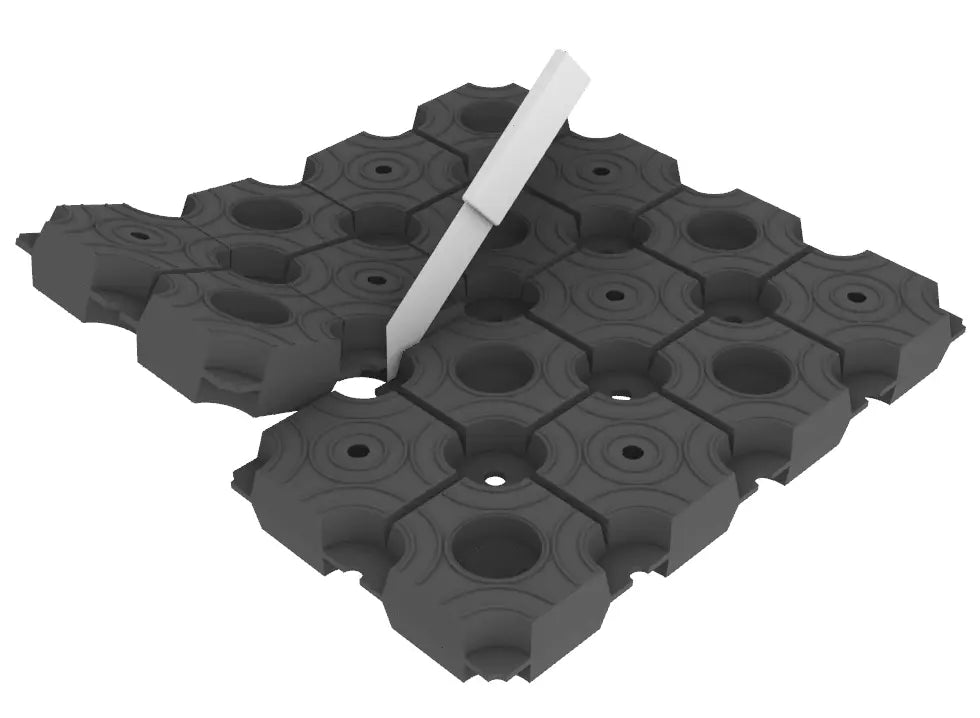 Gray interlocking floor tiles with a white tool.