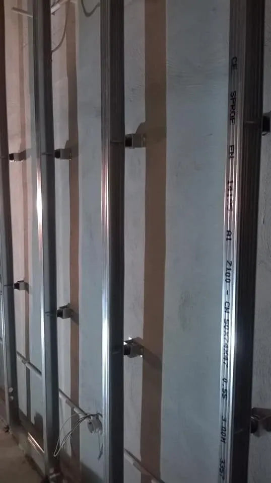 Metal studs on a white wall. Electrical wiring is exposed.