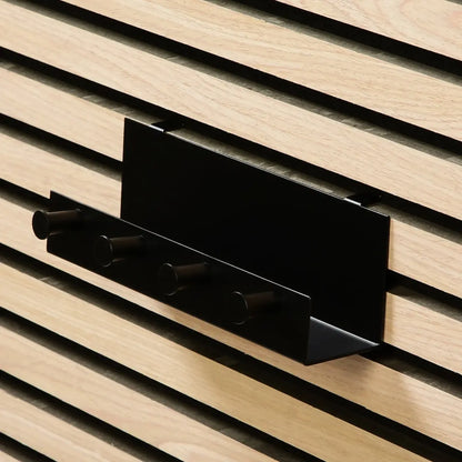 A black metal organizer shelf with hooks mounted on a paneled wall.
