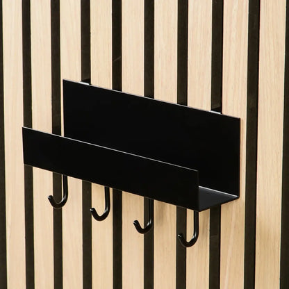 Black metal wall shelf with hooks attached to a wood slat wall.