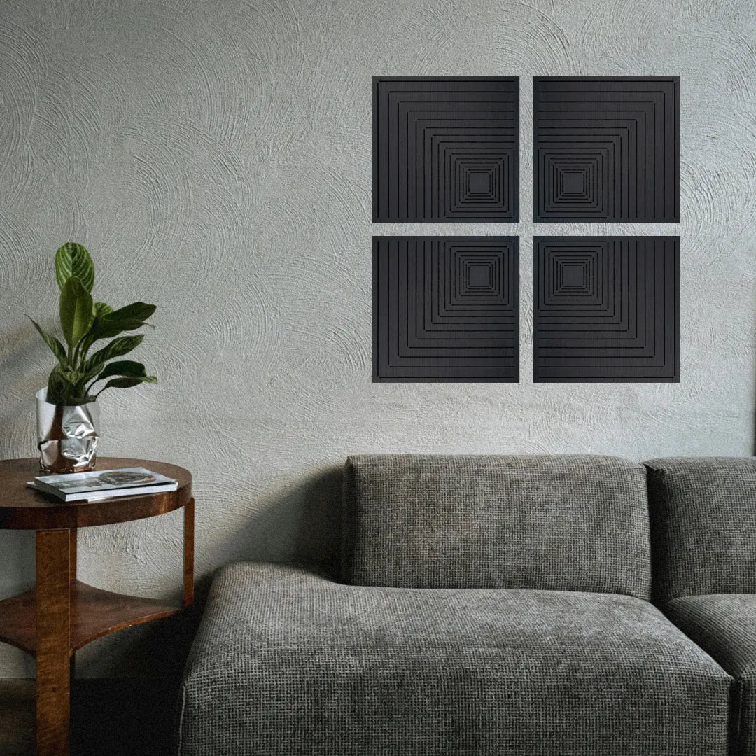 Black square acoustic panels on a gray wall above a gray sofa with a wooden side table and plant.