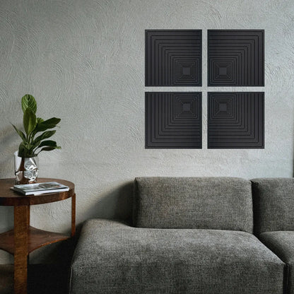 Black square acoustic panels on a gray wall above a gray sofa with a wooden side table and plant.