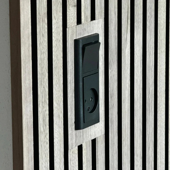Close-up of a black electrical switch and outlet mounted on a wooden slat wall.